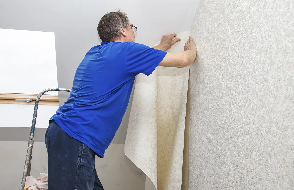 Applying wallpaper removal solution during an effective step-by-step wallpaper removal process
