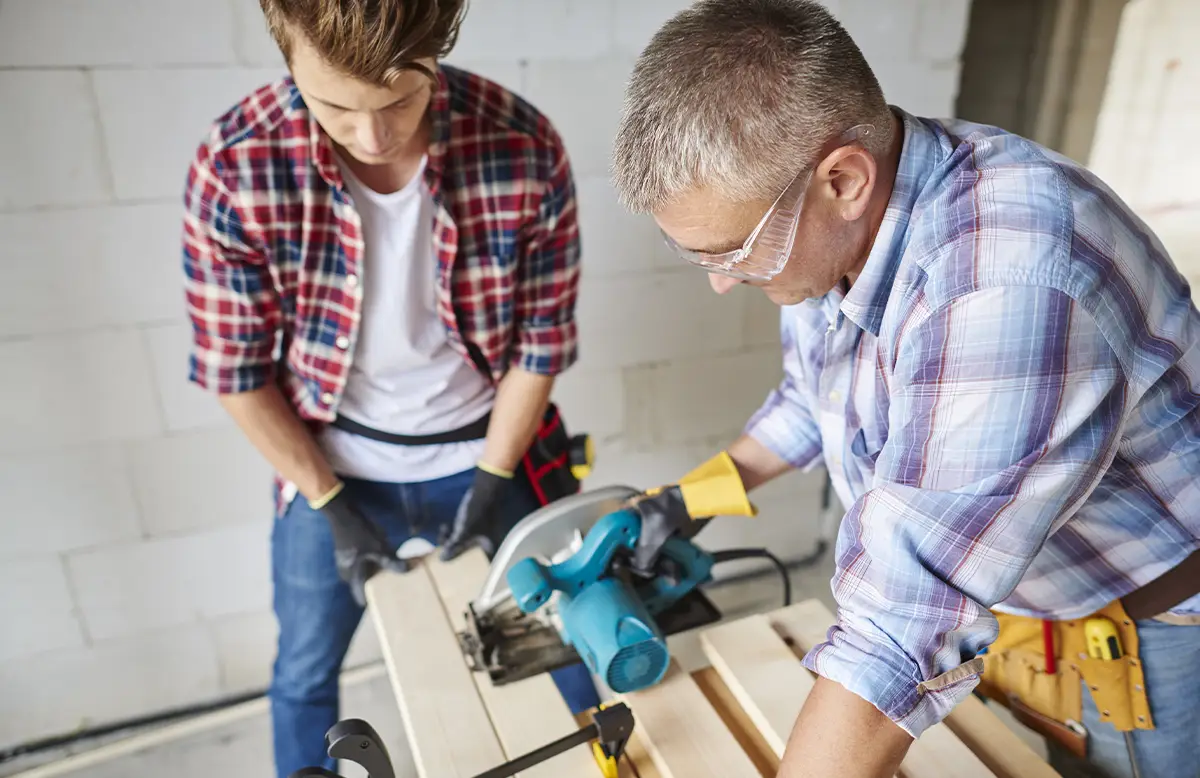 Handyman repairing a kitchen cabinet during home maintenance work